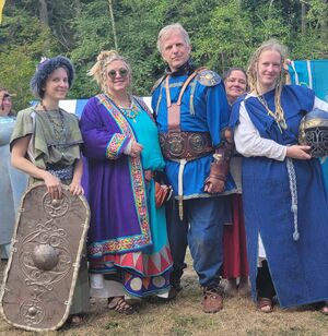 Four people in early Irish dress (and an extra head peeking out).